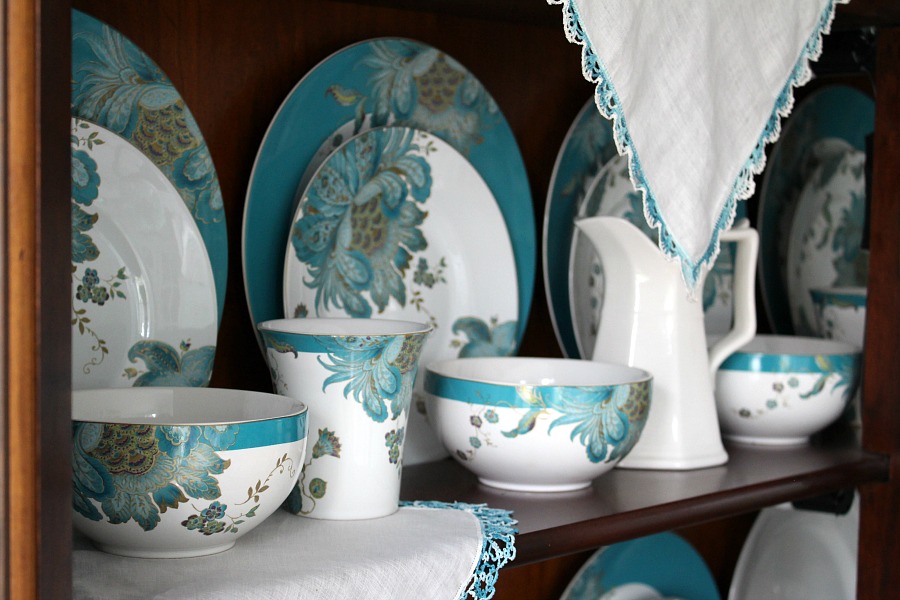 Dining room china cabinet with teal dinnerware dishes from 222 Fifth aqua and teal peacock pattern.