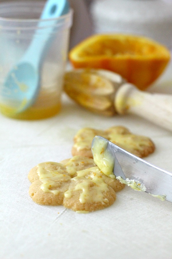 Frosted orange crisps are cookies flavored with orange in the dough and topped with a light orange frosting. They are crisp, tender and the citrus provides a nice surprise in each bite. Made using a cookie press similar to spritz or shortbread cookies but are sweeter. Perfect with a cup of tea, coffee or glass of milk.