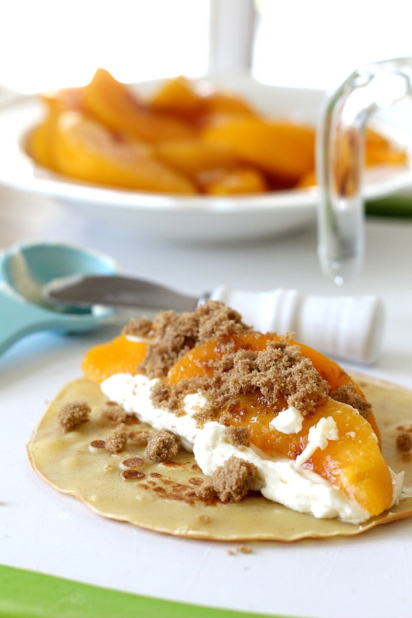 Peaches and Cream Cheese Crepes begins with a simple crepe, then filled with a sweetened cream cheese mixture, fresh sliced peaches, a sprinkling of brown sugar and a pat of butter that is then baked until warmed through. A dusting of confectioners' sugar and topped with whipped cream finishes this lovely dessert.