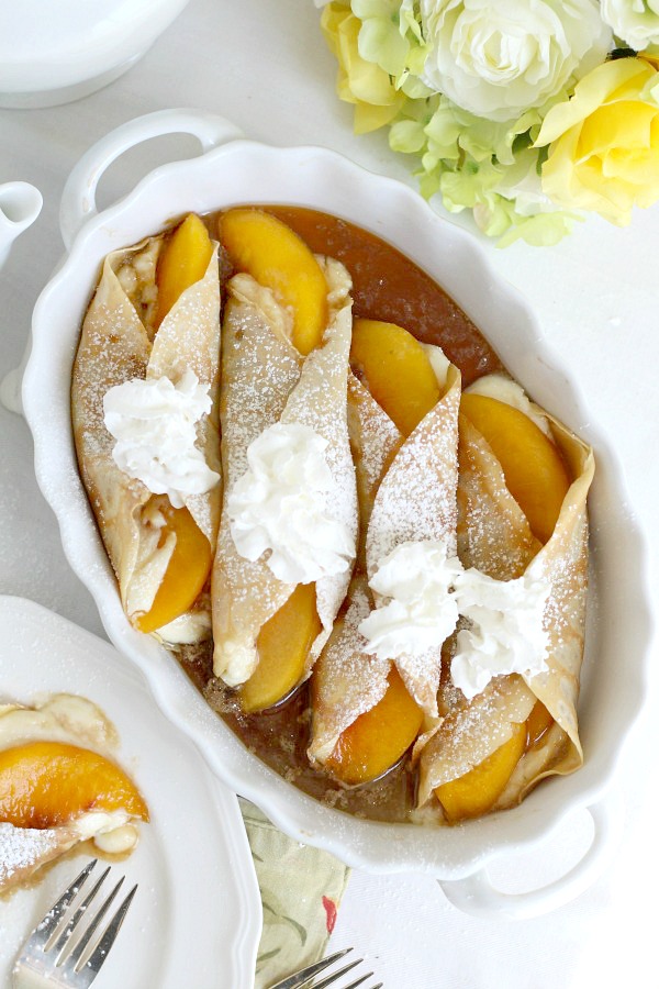 Peaches and Cream Cheese Crepes begins with a simple crepe, then filled with a sweetened cream cheese mixture, fresh sliced peaches, a sprinkling of brown sugar and a pat of butter that is then baked until warmed through. A dusting of confectioners' sugar and topped with whipped cream finishes this lovely dessert.