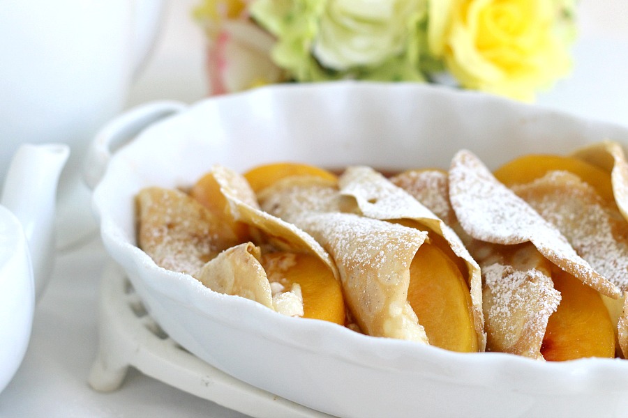 Peaches and Cream Cheese Crepes begins with a simple crepe, then filled with a sweetened cream cheese mixture, fresh sliced peaches, a sprinkling of brown sugar and a pat of butter that is then baked until warmed through. A dusting of confectioners' sugar and topped with whipped cream finishes this lovely dessert.