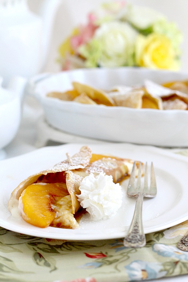 Peaches and Cream Cheese Crepes begins with a simple crepe, then filled with a sweetened cream cheese mixture, fresh sliced peaches, a sprinkling of brown sugar and a pat of butter that is then baked until warmed through. A dusting of confectioners' sugar and topped with whipped cream finishes this lovely dessert.