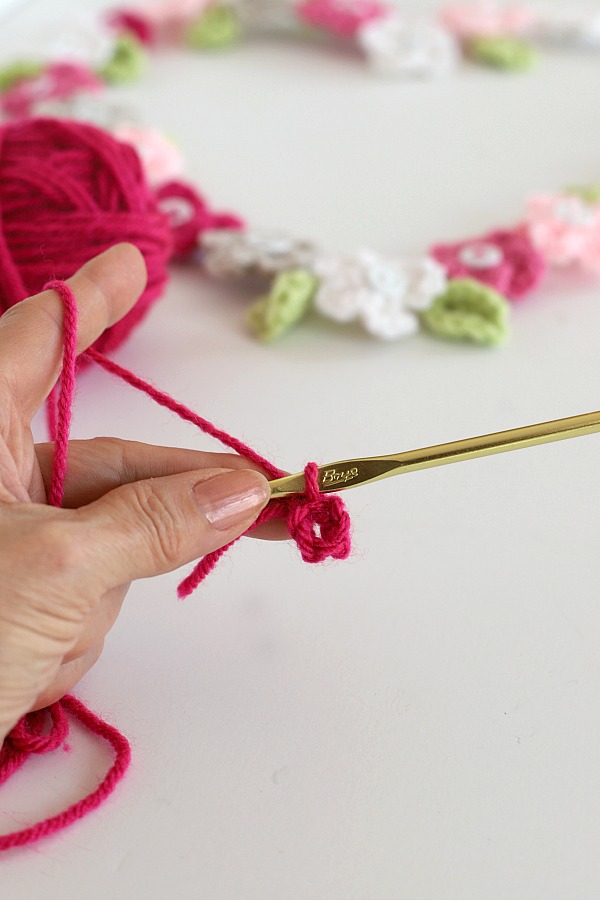 Quick, easy and perfectly pretty, this sweet crochet flower heart is cheerful, bright and a great craft for Valentine's Day. Easy pattern with step-by-step photos for heart, leaves and wreath construction.