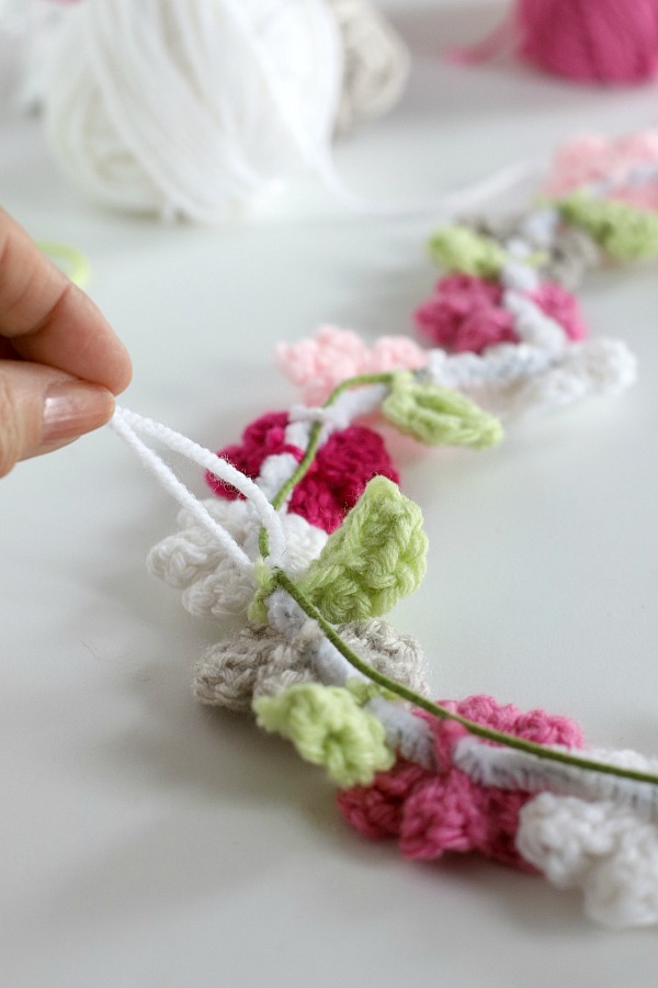 Quick, easy and perfectly pretty, this sweet crochet flower heart is cheerful, bright and a great craft for Valentine's Day. Easy pattern with step-by-step photos for heart, leaves and wreath construction.