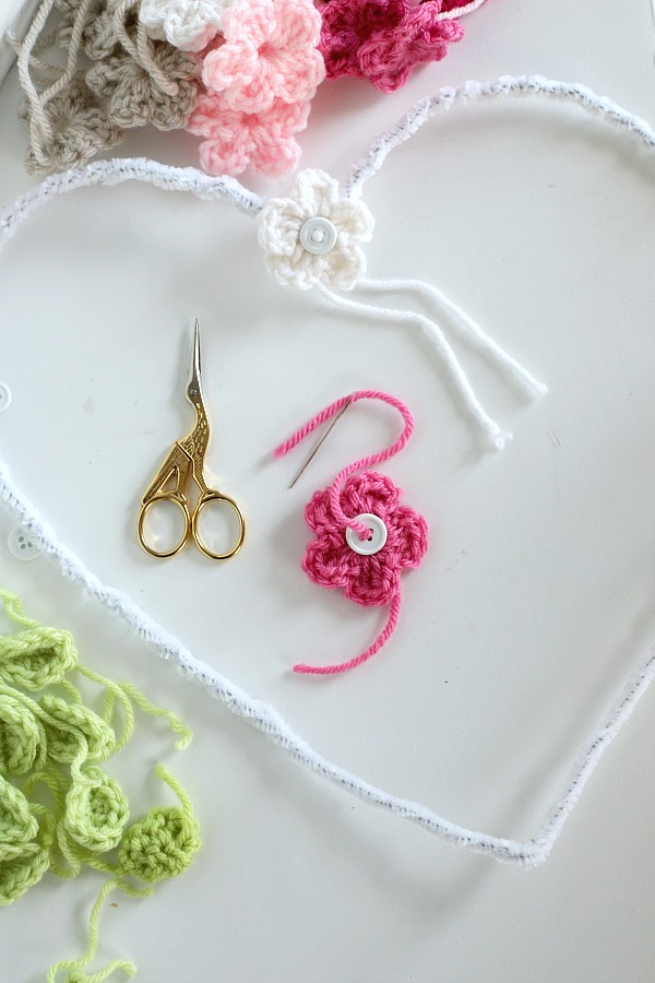 Quick, easy and perfectly pretty, this sweet crochet flower heart is cheerful, bright and a great craft for Valentine's Day. Easy pattern with step-by-step photos for heart, leaves and wreath construction.