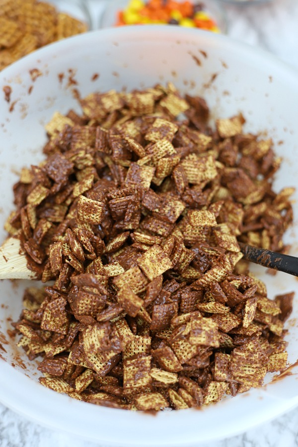 Easy to make, autumn puppy chow is a kid and adult favorite Halloween party snack. Chex mix, chocolate, peanut butter and candy corn tossed with confectioners sugar is a frightfully delicious concoction!