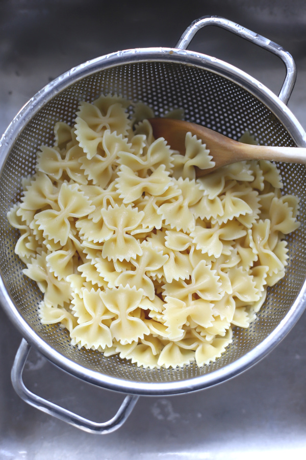 Make a big bowlful of creamy chicken pasta salad for dinner, lunch, potluck or cookout side dish. Easy recipe full of chicken, Parmesan, grapes and veggies with a fresh burst of basil.