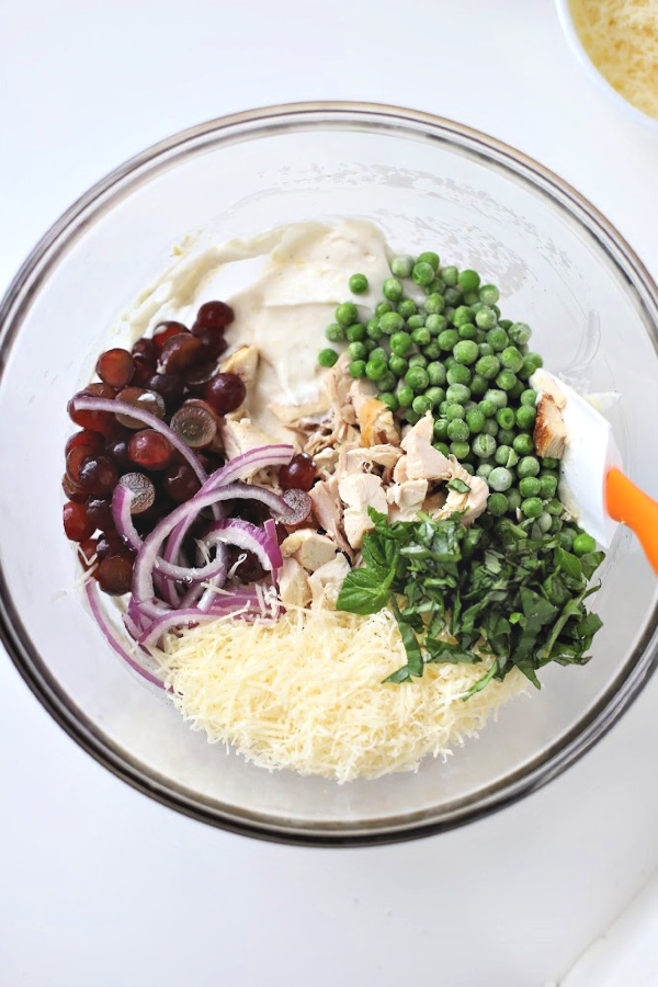 Make a big bowlful of creamy chicken pasta salad for dinner, lunch, potluck or cookout side dish. Easy recipe full of chicken, Parmesan, grapes and veggies with a fresh burst of basil.