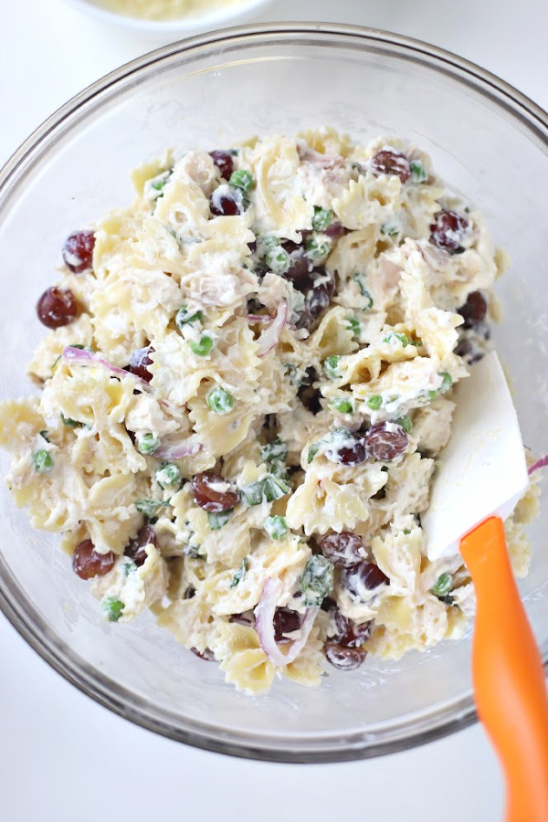 Make a big bowlful of creamy chicken pasta salad for dinner, lunch, potluck or cookout side dish. Easy recipe full of chicken, Parmesan, grapes and veggies with a fresh burst of basil.