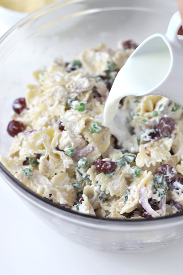 Make a big bowlful of creamy chicken pasta salad for dinner, lunch, potluck or cookout side dish. Easy recipe full of chicken, Parmesan, grapes and veggies with a fresh burst of basil.