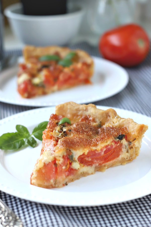 Easy recipe for basil tomato pie combines Roma tomatoes, creamy cheese in a flaky pastry crust. A bright and savory tart perfect as an appetizer or entrée meal.