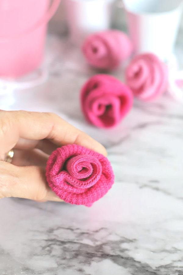 Easy step-by-step how-to for bud roses from baby socks. DIY flowers for shower corsage and décor ideas.