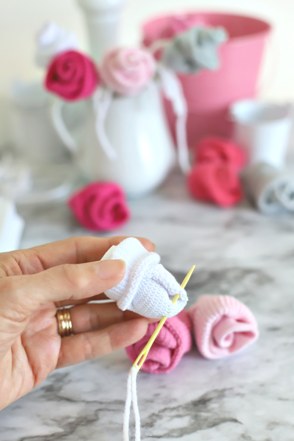 Easy step-by-step how-to for bud roses from baby socks. DIY flowers for shower corsage and décor ideas.