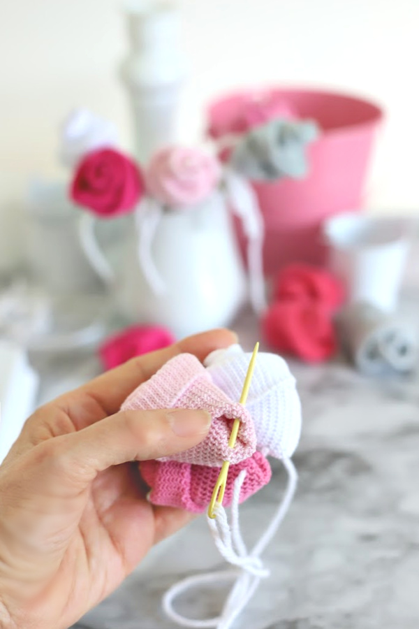 Easy step-by-step how-to for bud roses from baby socks. DIY flowers for shower corsage and décor ideas.