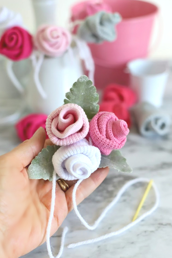 Easy step-by-step how-to for bud roses from baby socks. DIY flowers for shower corsage and décor ideas.