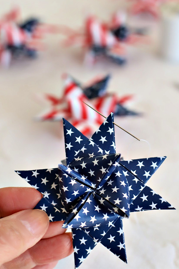 Easy step-by-step video tutorial how-to for patriotic paper stars perfect for 4th of July, Memorial Day or the military hero in your life. Made by folding and turning strips of paper creating a lovely 16-pointed, three dimensional ornament.