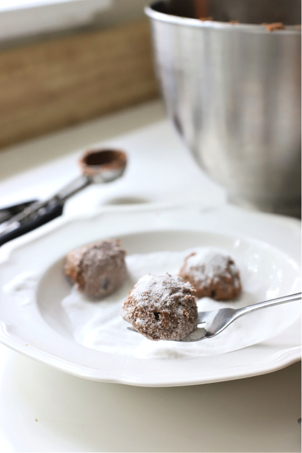 Rolling chocolate peanut butter cookie dough in sugar.