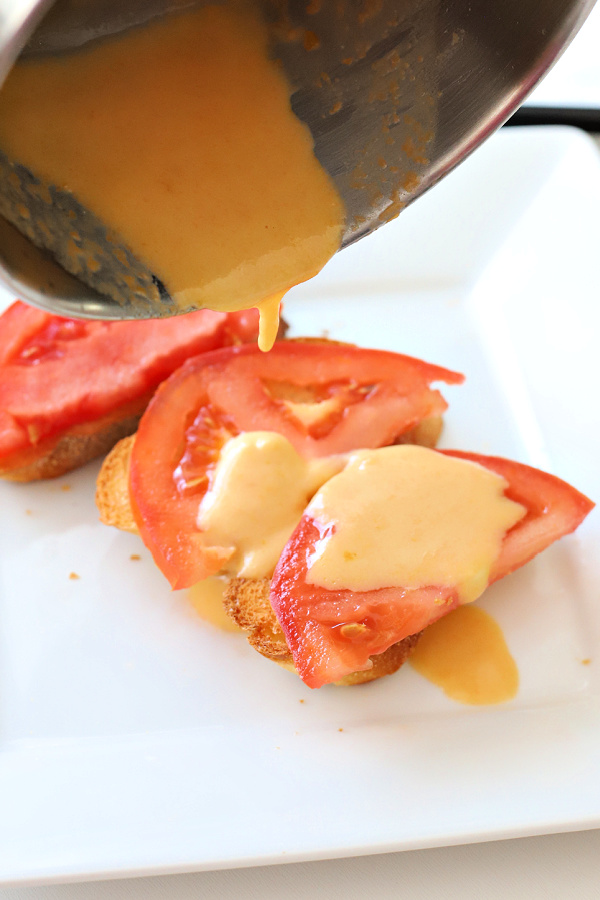 Pouring melted cheese over toast for Welsh rarebit