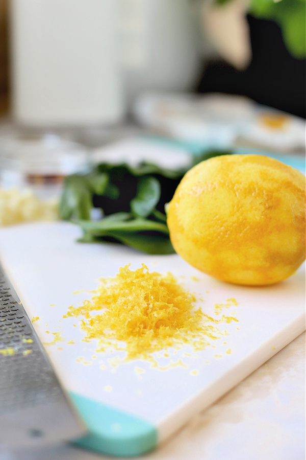 zesting a lemon for baked tomato & feta.