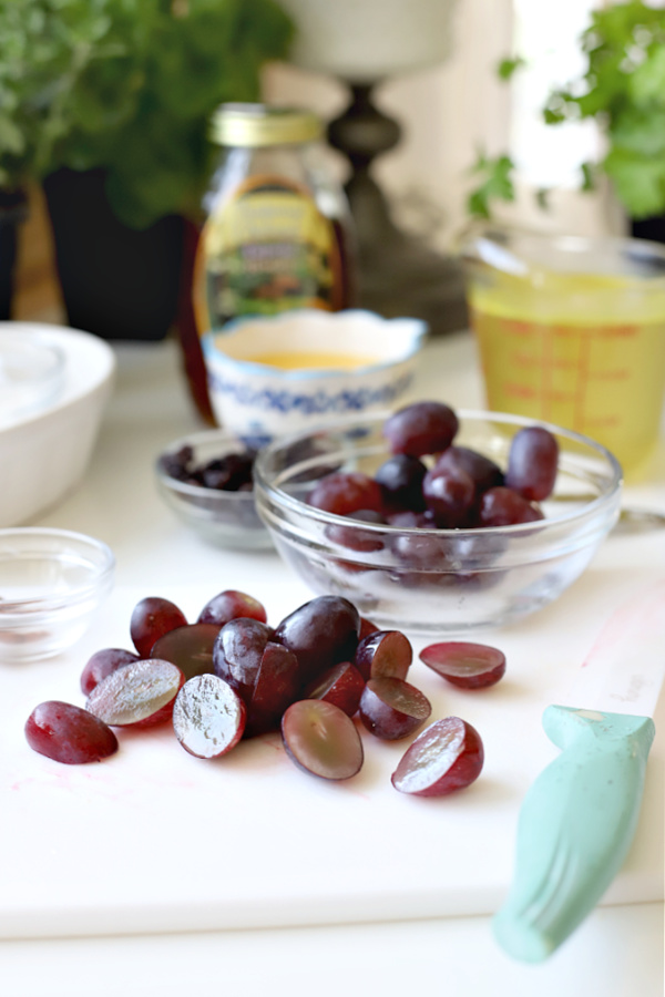 cutting red grapes in half for sauce