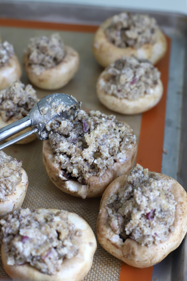 Adding the filling to sausage stuffed mushrooms