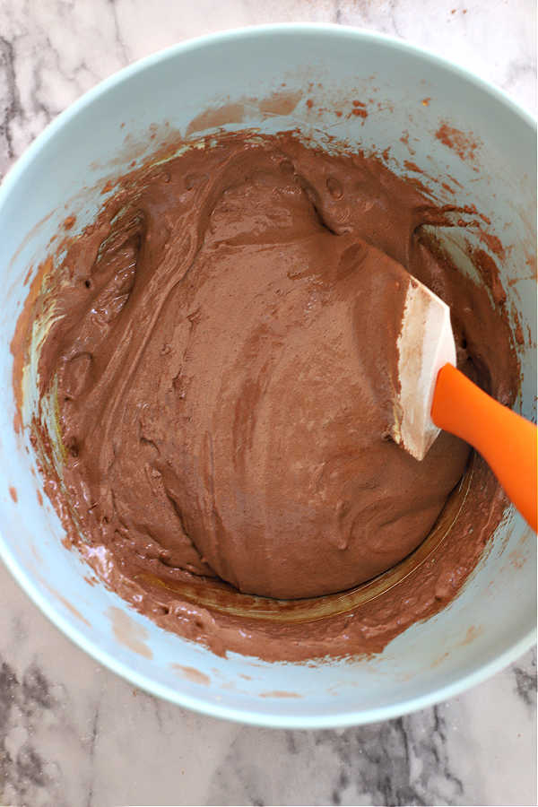 Folding the cocoa and flour into the beaten egg yolks.