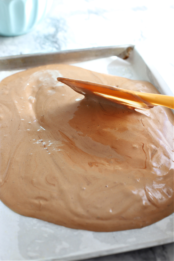 Spreading the mocha yule log cake batter in prepared jelly roll pan.