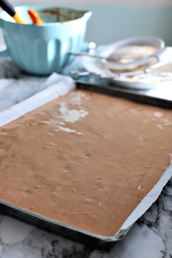 Spreading the mocha yule log cake batter in prepared jelly roll pan.