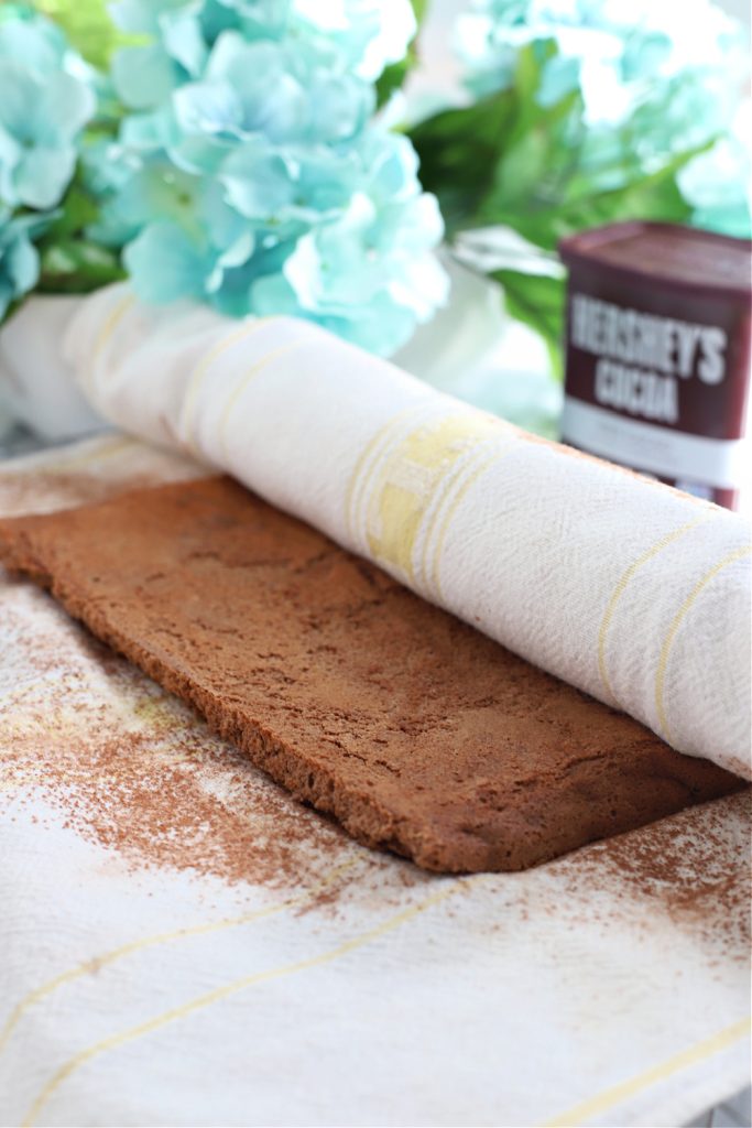 Rolling up the sponge cake in a towel to cool.