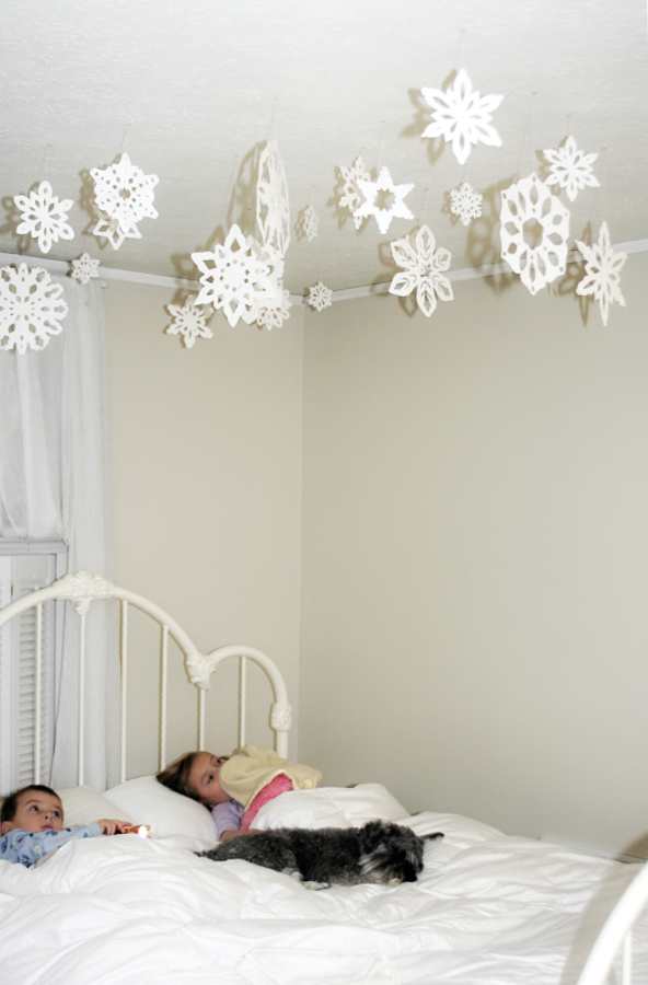 Winter decorating by hanging paper snowflakes to delight kids.