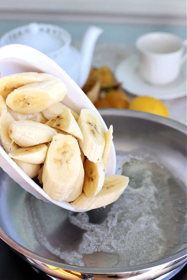 Adding fresh bananas to skillet for making sautéed bananas.