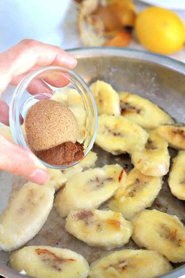 Adding brown sugar and cinnamon to skillet for fried bananas.