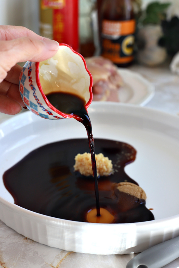 Adding soy sauce for honey ginger air fryer chicken thighs.