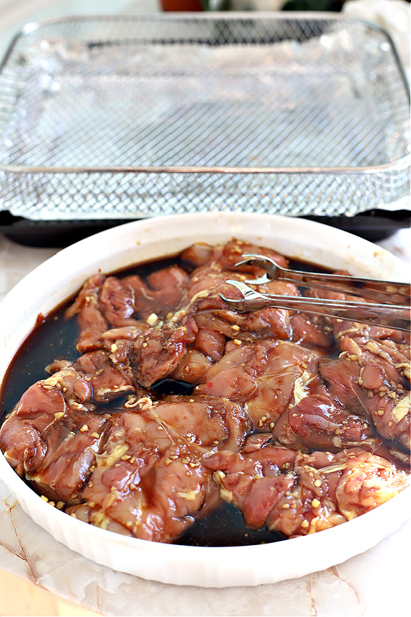 Marinating skinless, boneless chicken thighs for cooking in the air fryer.