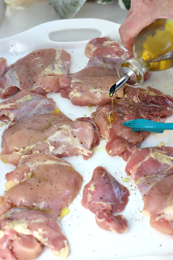 Adding oil for making skinless, boneless BBQ chicken thighs in the air fryer. oil for making BBQ air fryers chicken thighs.