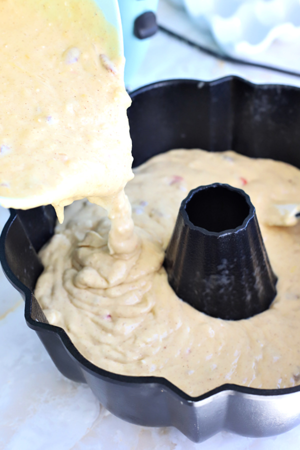 Pouring the hummingbird cake batter into prepared Bundt pan.