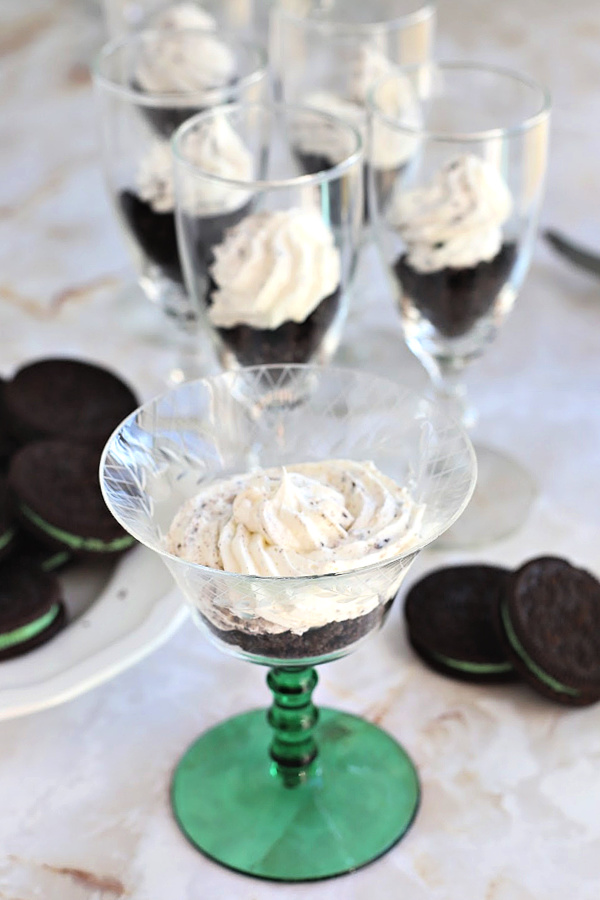 Layering the minty cookie crumb mixture with cheesecake swirl for chocolate parfait dessert.