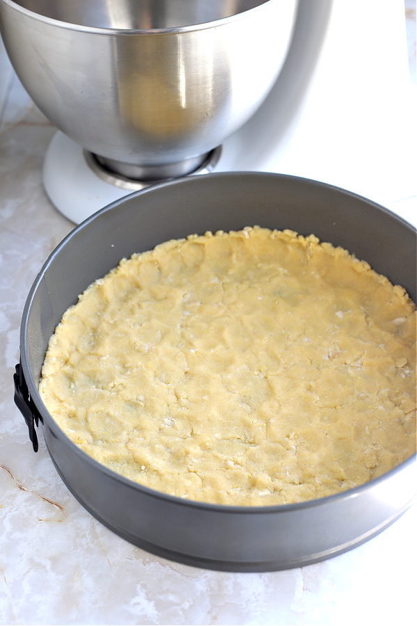 Pressing the crust into a springform pan for NY style cheesecake recipe.