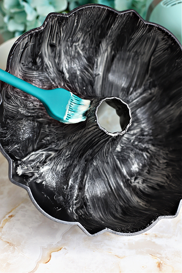 Spreading a Bundt pan with the 3 ingredient Goop easy pan release for baking.