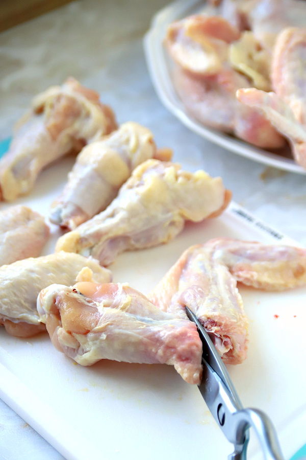 Cutting the joint sections for preparing honey garlic chicken wings recipe.