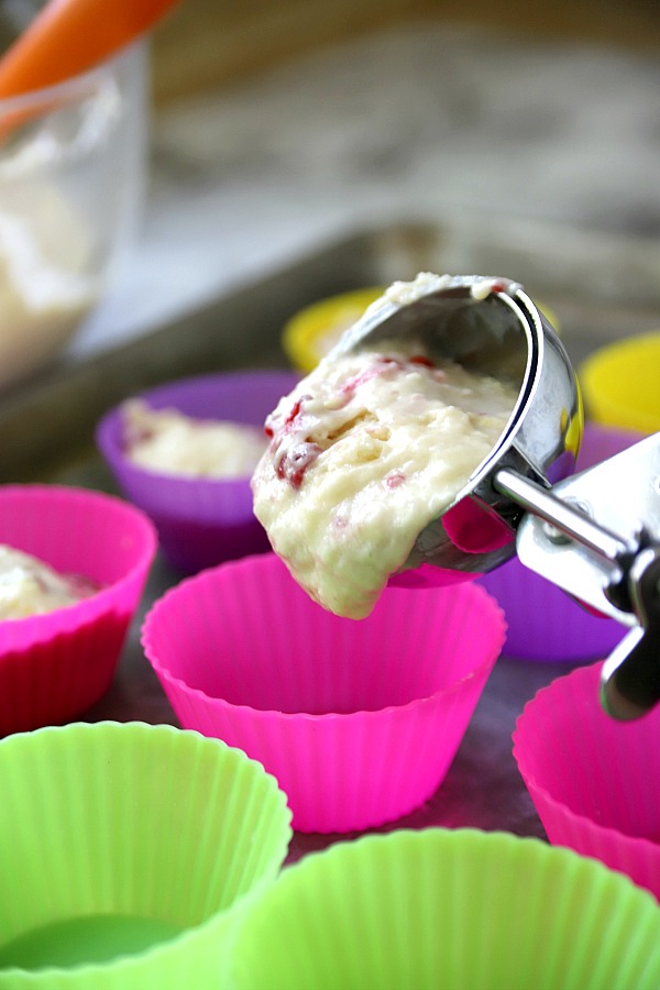 Filling tin with batter for raspberry very berry muffins recipe.