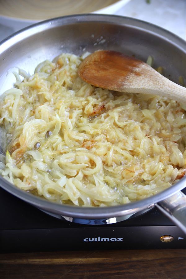 Caramelizing sliced onions and butter for English pub style bangers and mash with onion gravy recipe.