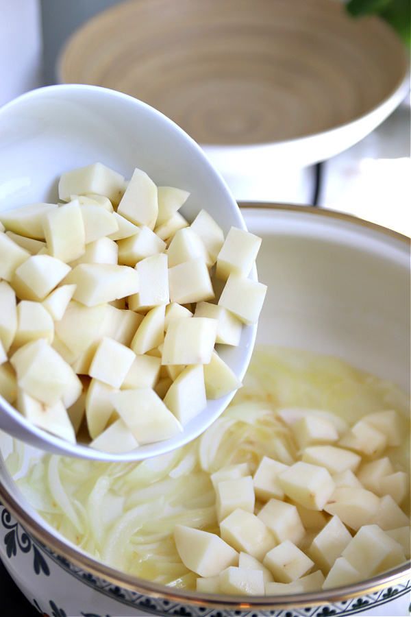 Adding potatoes to post for shrimp and corn chowder.