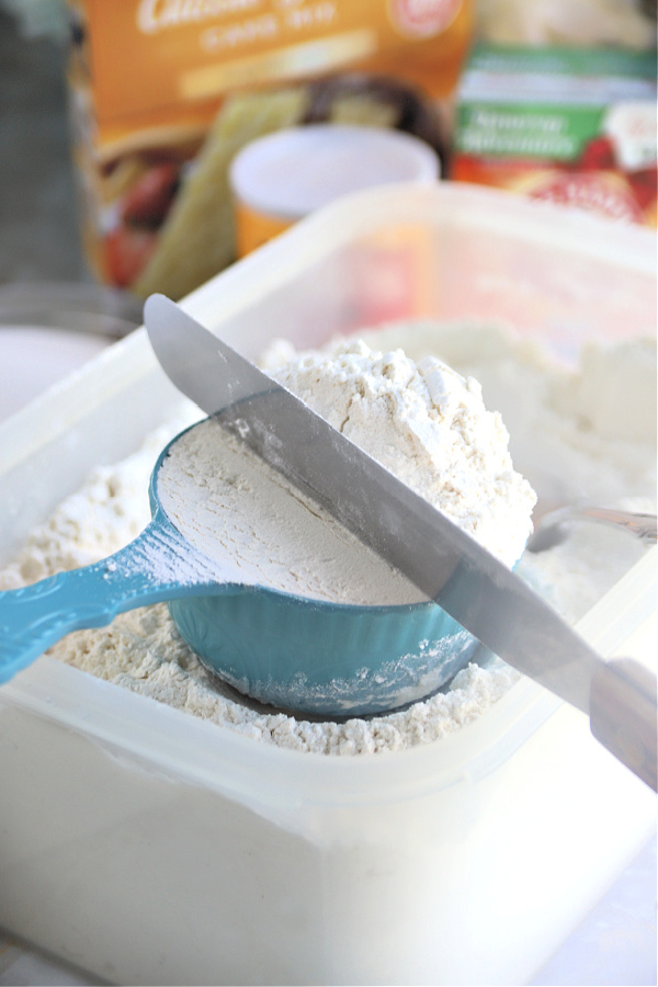 Leveling flour in measuring cup for how to properly measure flour.