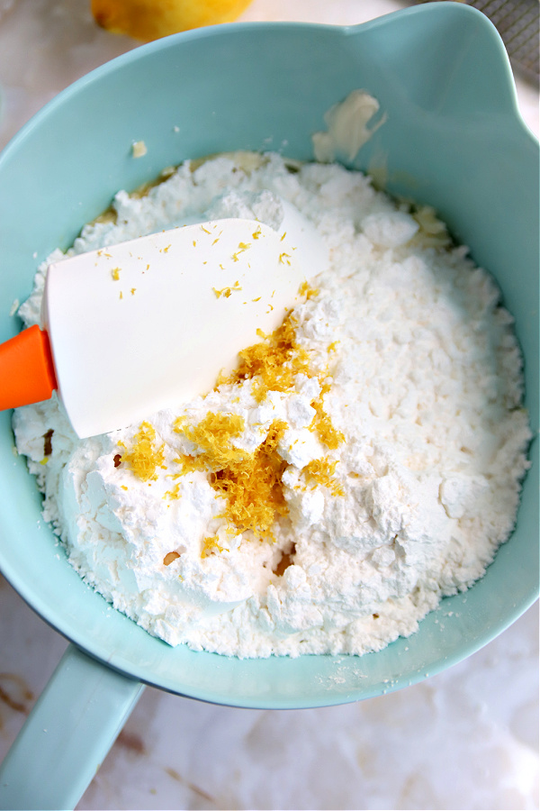 Creaming together butter and cream cheese for lemon sheet cake frosting.