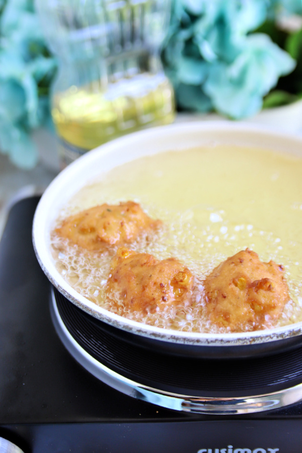 Frying corn fritters in hot oil.