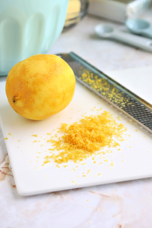 zesting a fresh lemon for making the cream cheese frosting for lemon sheet cake.