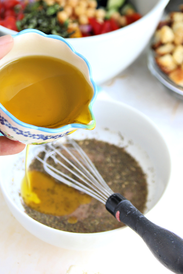 Making the dressing for Greek panzanella salad.