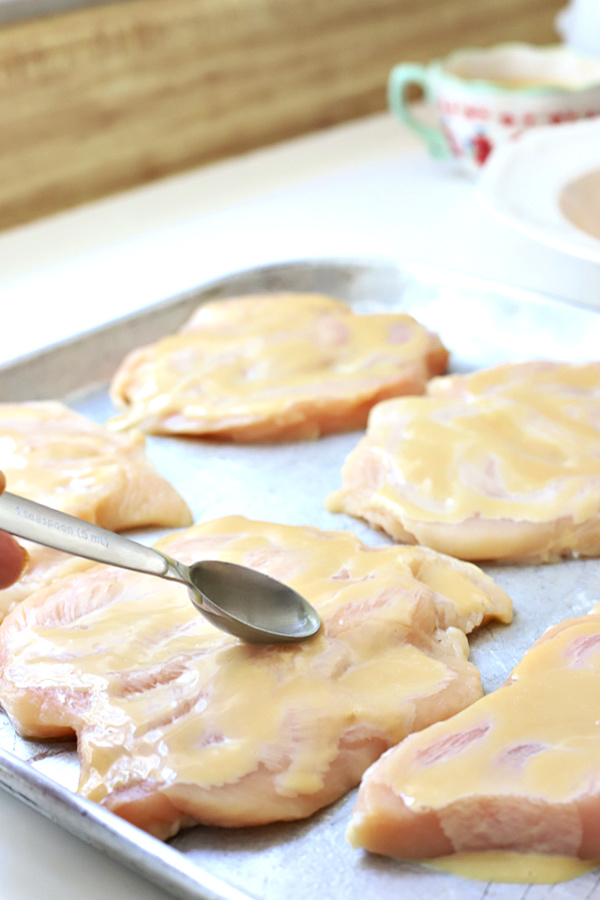 Easy recipe for juicy chicken breasts with a crispy Parmesan and panko coating. Oven baked rather than fried, Parmesan crusted chicken is drizzled with honey mustard sauce. 