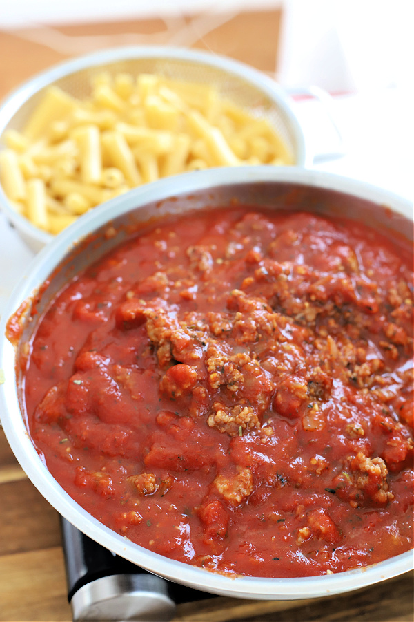 Simmering the browned Italian sausage, herbs, basil, garlic and tomato sauce for baked ziti.